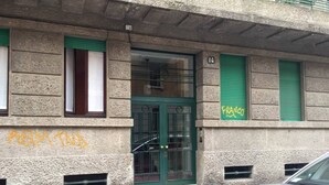 A building with a green door, numbered 14, and a window with green shutters. Graffiti is visible on the wall. - JOIVY Wooden Guerrini Apartment (Milan)