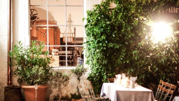 An outdoor seating area with potted plants, a table, and chairs. - Hotel & Brauereigasthof Kapplerbräu (Altomunster)