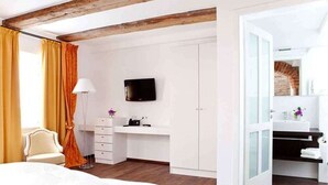 A modern hotel room with a bed, a desk with a flat-screen TV, a wardrobe, and a bathroom with a mirror and sink. - Hotel & Brauereigasthof Kapplerbräu (Altomunster)