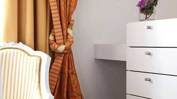 A bathroom with a white cabinet, a striped towel, and a vase with flowers on the counter.