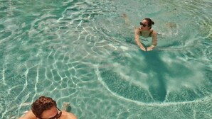 Una piscina nítida amb reflexes i una persona nedant.