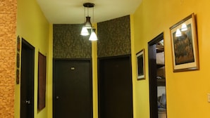A hallway with a patterned floor, a bench, and doors leading to other areas. - Hotel Sweet Inn (Lahore)