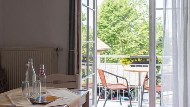 A room with a table, chairs, and a view of the outdoors. - Hotel Garni (Isny im Allgaeu)