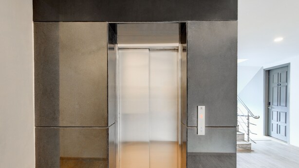 An elevator with a metallic finish and a control panel on the right side. - Hotel Aravali Inn & Banquet Hall (Faridabad)