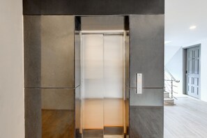Een lift met een metalen afwerking en een bedieningspaneel aan de rechterkant.