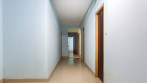 A long, narrow hallway with light blue walls and a beige floor.