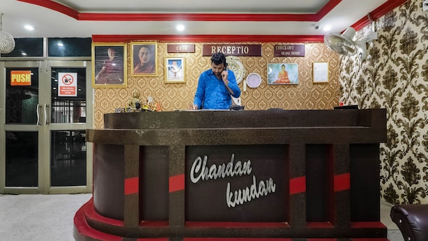 Ein Empfangsschalter mit einem Schild, auf dem 'Chandan kundan' steht, und ein Mann, der dahinter steht.
