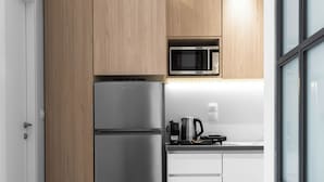 A modern kitchen with wooden cabinets, a stainless steel refrigerator, a microwave, and a kettle on the countertop. - DeniZen Boutique Apartments, Nilie Hospitality MGMT (Thessaloniki)