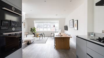 Una cocina moderna con horno Bosch, una mesa de comedor de madera y un amplio ventanal que proporciona luz natural.