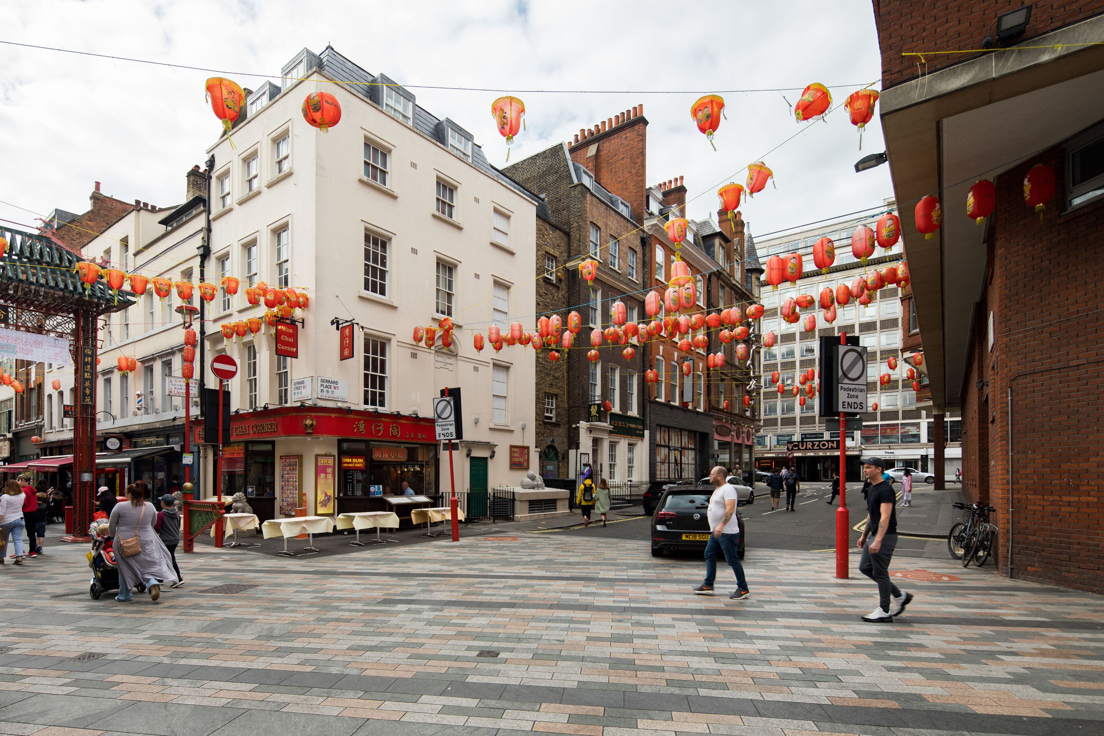 A street with buildings, a pedestrian crossing, and red lanterns.