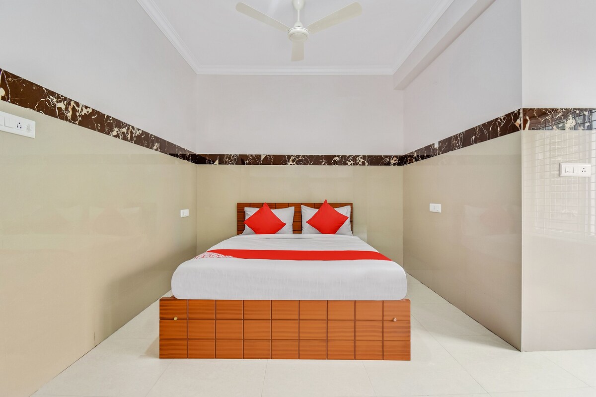 A bedroom with a bed, a ceiling fan, and a wooden headboard.