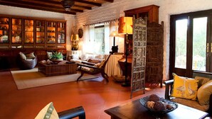 Un salon chaleureux avec une cheminée, des meubles en bois et une grande fenêtre offrant une belle vue.