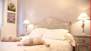 Ein Schlafzimmer mit einem Holz-Kopfteil, zwei Nachttischlampen und einem Nachttisch mit Schublade.
