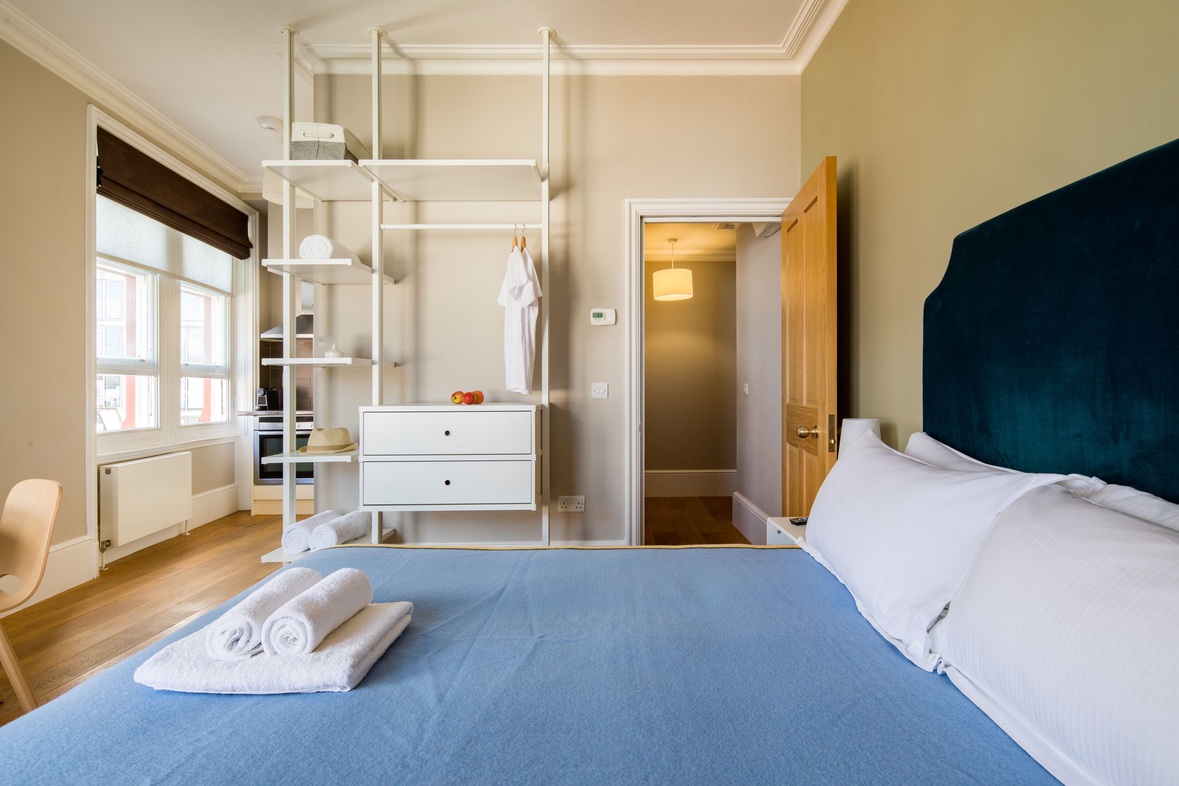 Ein Hotelzimmer mit Bett, Schreibtisch, Stuhl, Kleiderschrank und Fenster.