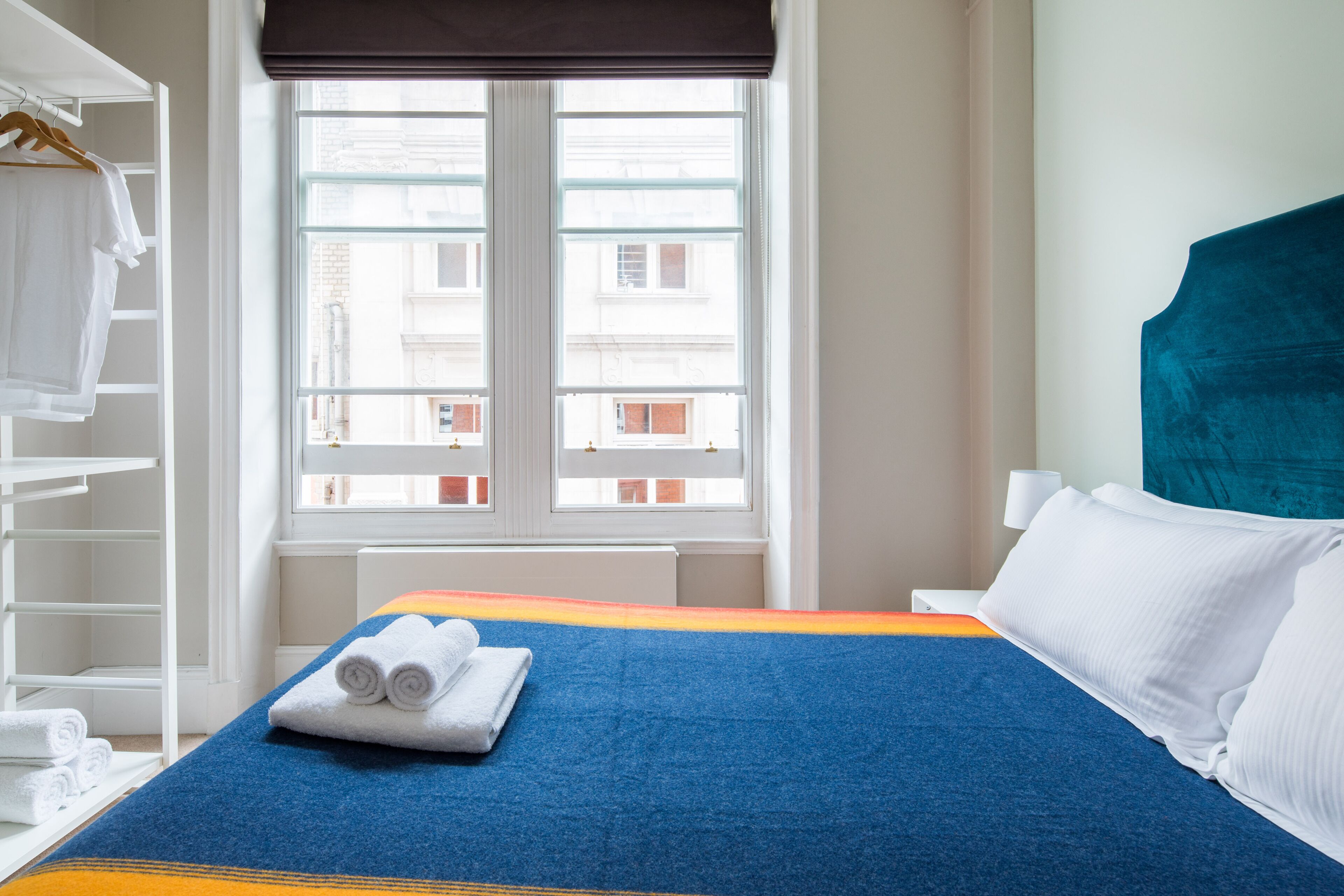 Ein Hotelzimmer mit Bett, Fenster und Kleiderschrank.