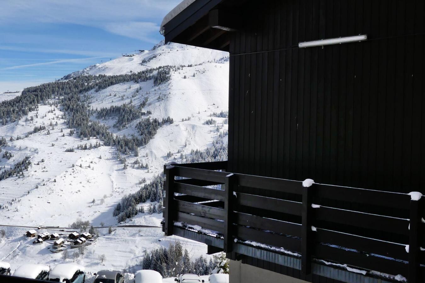 A mountain view with a wooden building and a snow-covered landscape.