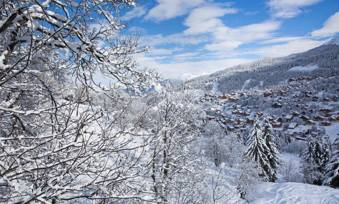Eine verschneite Berglandschaft mit einer Gruppe von Holzhütten.
