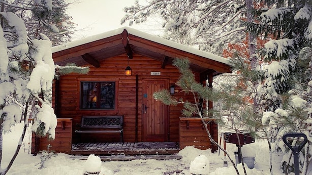 A wooden cabin with a snow-covered roof and a number '15889' on the door.