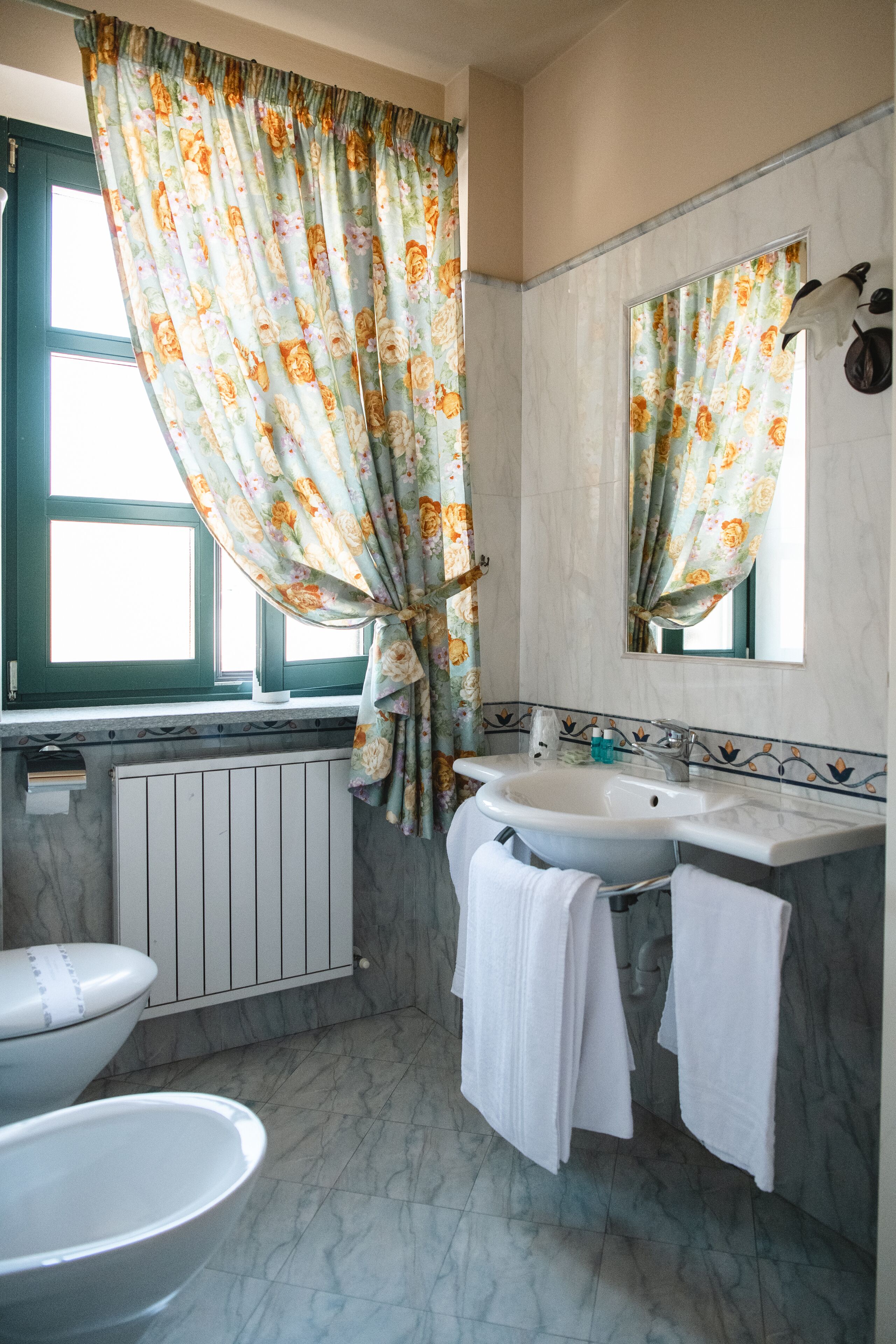 A bathroom with a toilet, bidet, and sink.