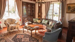 A cozy living room with a brown leather sofa, patterned rug, wooden coffee table, and a blue armchair.