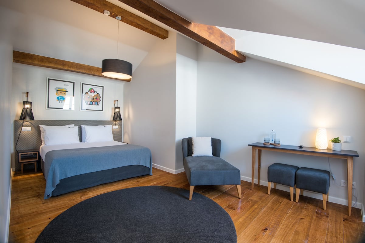 Une chambre à coucher avec un lit, des tables de chevet, un bureau, une chaise et un tapis rond.