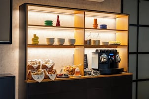 Una mesa de buffet con diferentes tipos de comida y una máquina de café.