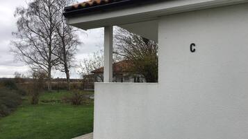 A white building with a tiled roof and a letter 'C' on the wall.