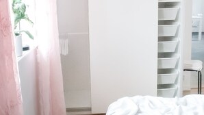 A bedroom with a bed, a wardrobe, and a shelving unit. - Nordanå Gård (Vinslov)