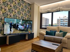 Relax in this stylish living room with a flat-screen TV, comfortable sofa, and beautiful city views.