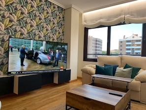 Relax in this stylish living room with a flat-screen TV, comfortable sofa, and beautiful city views.