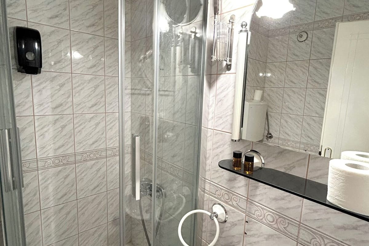 basic double room, city view | bathroom | shower, hair dryer, slippers, towels