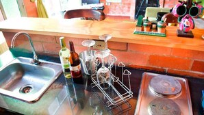 Uma cozinha com pia, uma garrafa de vinho e um suporte para copos de vinho.