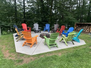 Guests can relax in Adirondack chairs around a central fire pit on the patio.