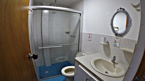 Ein kleines Badezimmer mit Dusche, Toilette und Waschbecken.