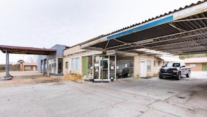 A gas station with a blue canopy, a service window, and a parked truck. - OYO Hotel Holly Springs MS (Holly Springs)