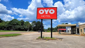 A hotel sign with the name "OYO HOTEL" against a blue sky with clouds. - OYO Hotel Holly Springs MS (Holly Springs)
