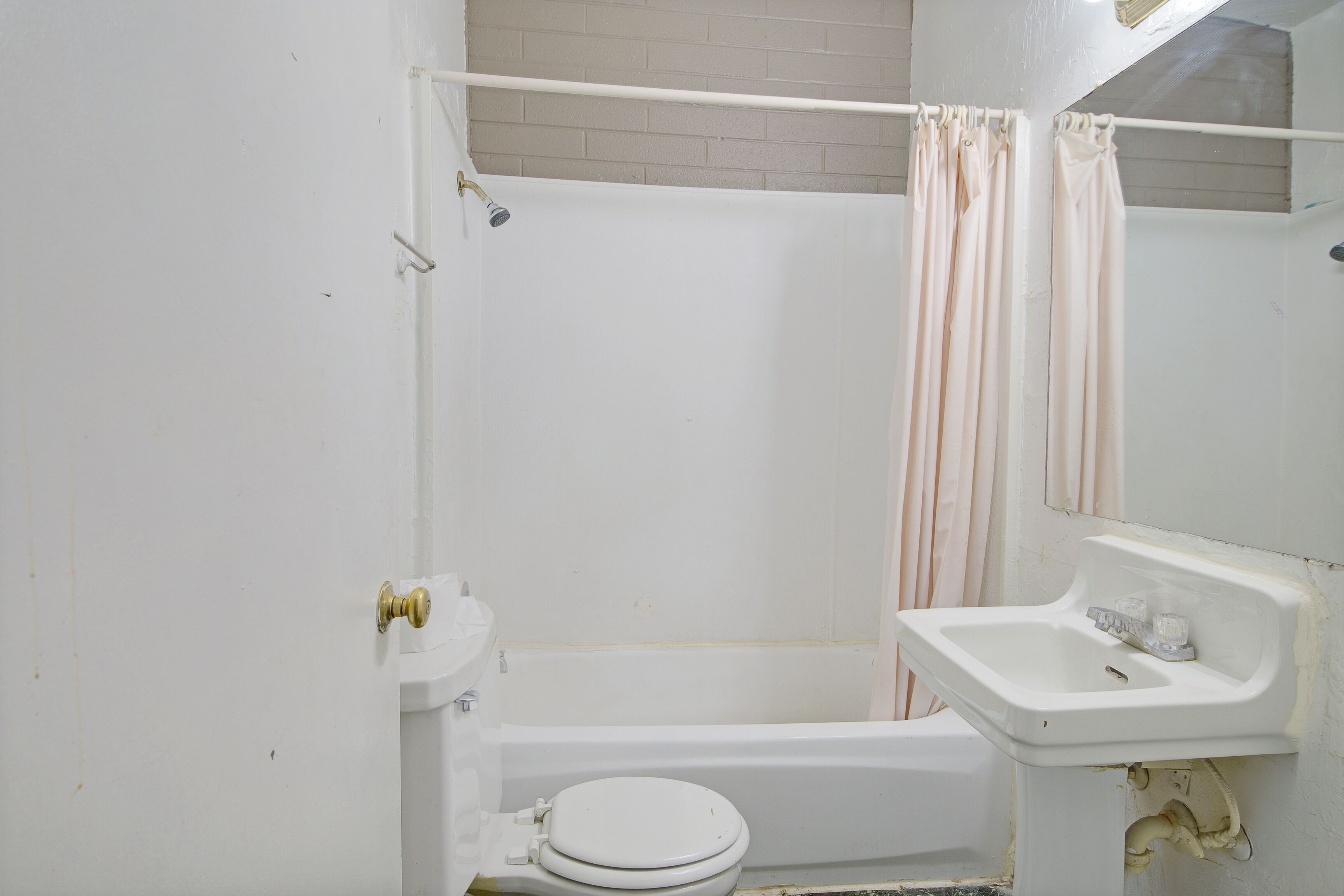 A bathroom with a toilet, sink, and bathtub.