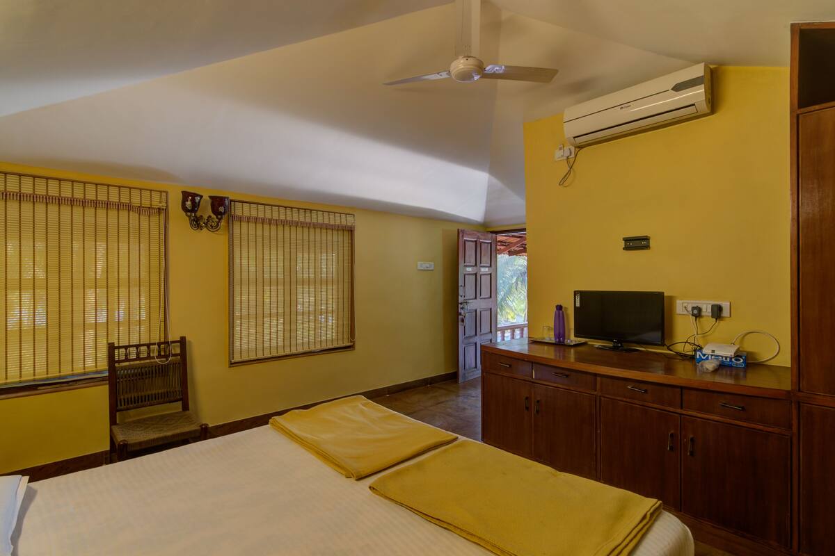 Une chambre comprenant un lit, un bureau, une chaise, un téléviseur et un appareil de climatisation.