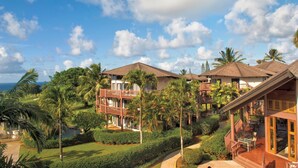 A resort with multiple buildings, lush greenery, and a clear sky.