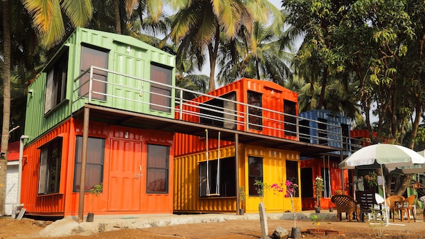 A multi-level houseboat with a balcony, surrounded by palm trees. - IORA Cottages (Alibag)