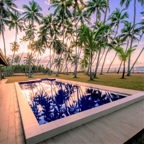 A swimming pool with a view of palm trees and a sunset. - Arhimser Villa (Kahandamodara)