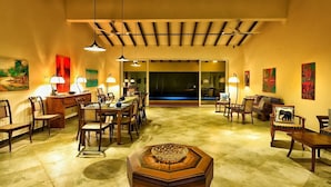 A spacious dining area with a long table and chairs, a central decorative table, and a view of a pool through a glass door. - Arhimser Villa (Kahandamodara)