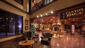A spacious lobby with leather armchairs, a Christmas tree, and a fireplace. - Glacier Canyon Resort With Free access to WaterParks and other Amenities (Baraboo)