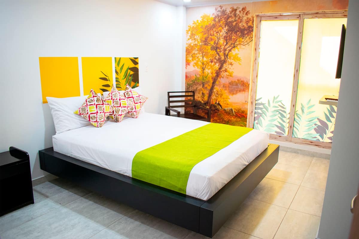 Un dormitorio moderno con cama, mesita de noche y una silla.