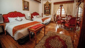 A hotel room with two beds, a dining area, and a large mirror. - Casona Corrales Hotel Boutique (Cusco)