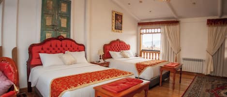 Une chambre d’hôtel avec deux lits, un lustre, un plancher en bois et une grande fenêtre avec des rideaux.