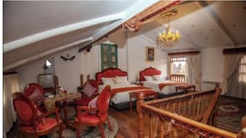 A traditional room with two beds, a chandelier, and a wooden staircase.