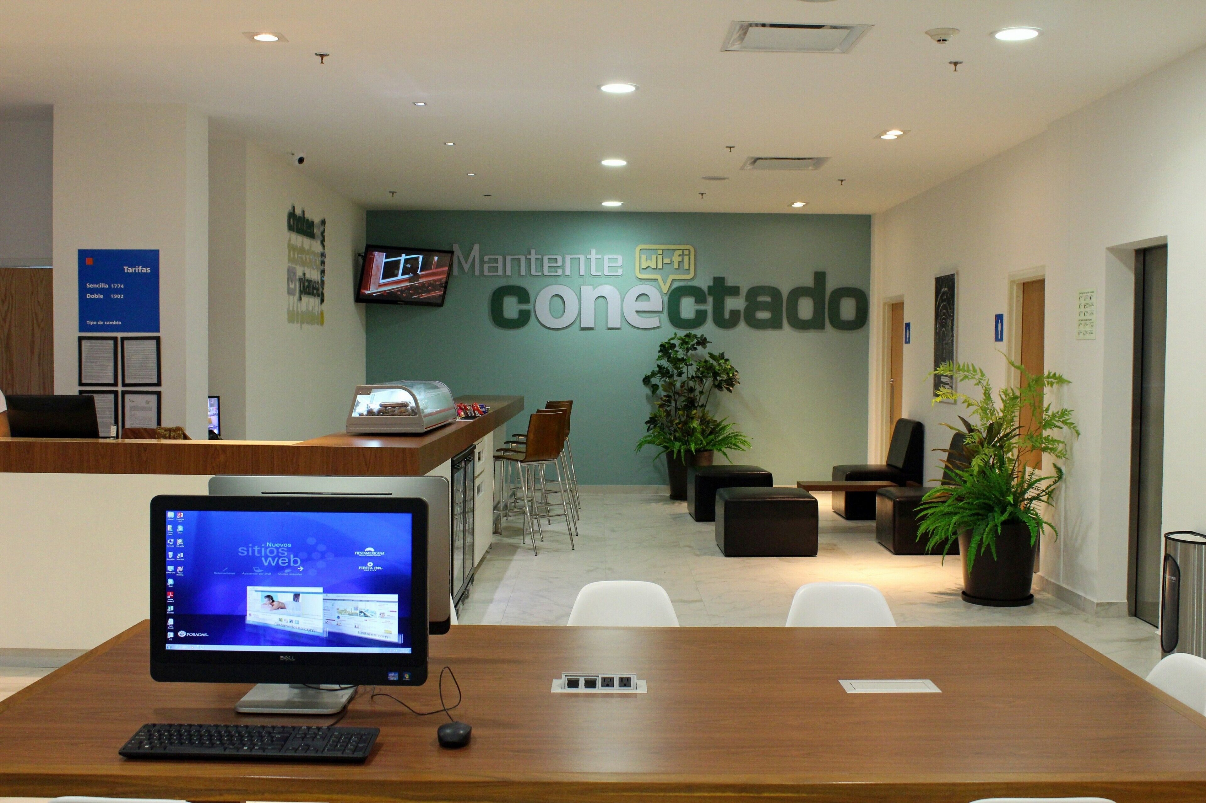 A reception area with a desk, computer, and seating.