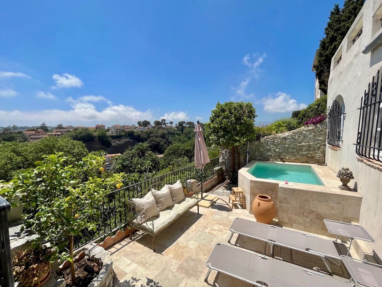 Une terrasse sur le toit avec une piscine, des espaces de détente en plein air et une vue sur le paysage environnant.
