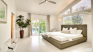 A modern bedroom with a large bed, a ceiling fan, a potted plant, and a view of the outdoors. - Feel Hawaii. Magnificent view. Family Reunion Home. Children friendly. (Waianae)